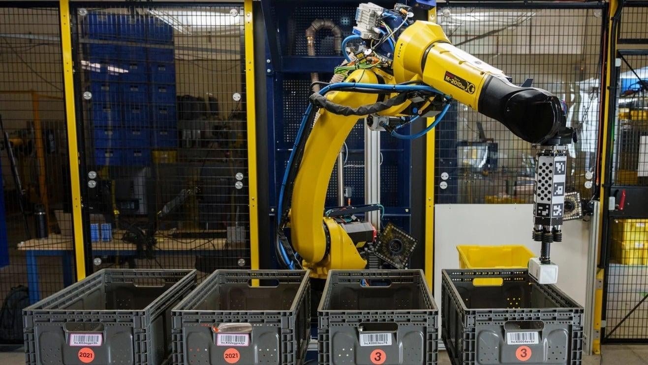 Robotic arm sorting items into four boxes